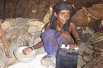 Frau bereitet in der Huette den Brotteig zu